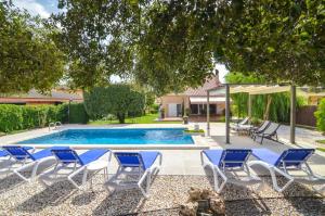una piscina con tumbonas azules y blancas y una piscina en Club Villamar - Terentia, en Maçanet de la Selva