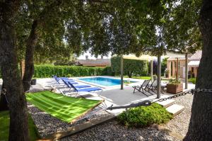 uma piscina com espreguiçadeiras e uma rede de descanso em Club Villamar - Terentia em Maçanet de la Selva