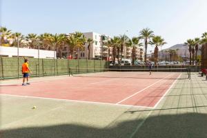 2 persone che giocano a tennis su un campo da tennis di HomeForGuest Modern and recently renovated apartment in Arona ad Arona