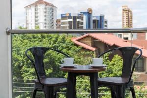due sedie e un tavolo con due tazze sul balcone di Fiori Apartments a Santa Cruz de la Sierra