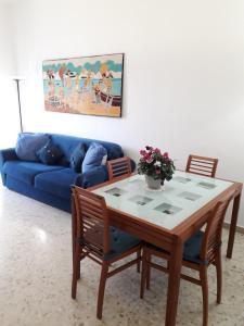 un soggiorno con tavolo e divano blu di Sweet Carola a Bari