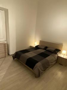 una camera con un grande letto con due lampade di - A casa tua - House a Catania