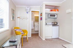 uma pequena cozinha com uma cadeira amarela e uma mesa em STUDIO @ 91 em Whanganui
