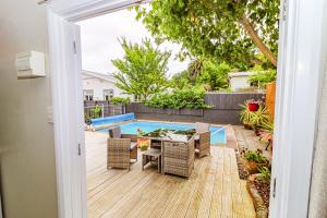 um pátio com uma mesa e cadeiras e uma piscina em STUDIO @ 91 em Whanganui