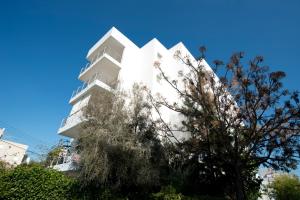 a white building with a tree in front of it at Glabur Stays - The Cozy Atelier - Nicosia City, Free Parking & Wifi, Welcomes You!!! in Nicosia
