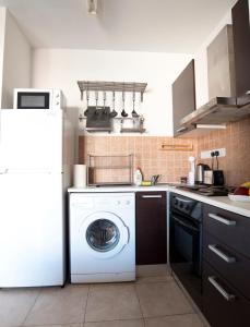 a kitchen with a washing machine and a refrigerator at Glabur Stays - The Cozy Atelier - Nicosia City, Free Parking & Wifi, Welcomes You!!! in Nicosia