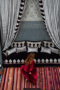 a girl is laying on a bed in a room at Riad Fes Nass Zmane in Fez