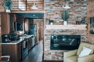 a kitchen with a brick wall and a couch at Tiny Homes at Powderhorn Mountain Resort in Mesa