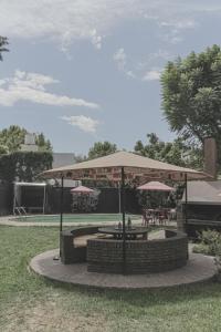 un pabellón con mesas y sombrillas en un parque en Break Point - bed and breakfast en Mendoza
