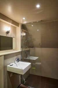 a bathroom with a sink and a shower at Gîte La Passerelle - Manoir le Plessix Madeuc in Corseul