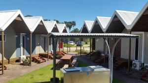 a row of houses with awnings and a picnic table at NRMA Batemans Bay Resort in Batemans Bay