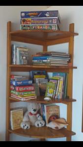 a book shelf filled with books and a teddy bear at La casa de Mabel in Las Grutas