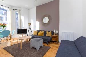 un soggiorno con divano blu e tavolo di Stylish 2 Bed Apartment-Zone 2 - 10 Minutes to the heart of London a Londra