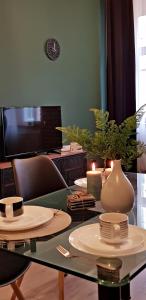 a living room with a table with plates and a tv at Centrum Kupiecka Apartment in Zielona Góra