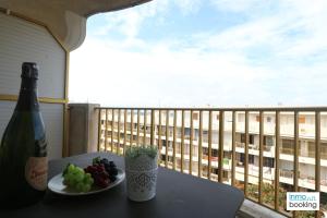 a bottle of wine and grapes on a table on a balcony at Experience Internacional Salou - Climatizado con piscina in Salou