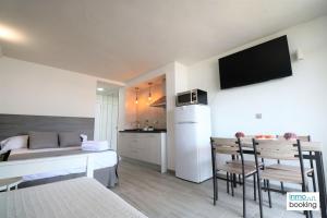 a bedroom with a bed and a kitchen with a table at Experience Internacional Salou - Climatizado con piscina in Salou