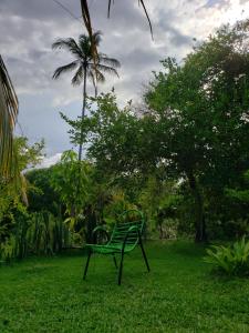 a green bench sitting in the grass in a yard at Casa Branca in Atins