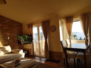 a living room with a couch and a table and a television at Villa Jupok in Bar