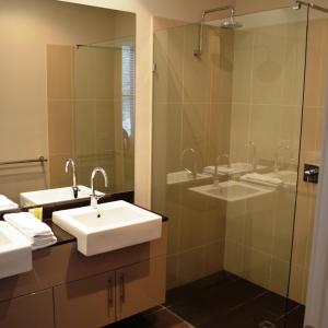 a bathroom with two sinks and a glass shower at LVista Lorne in Lorne