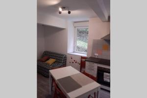 uma pequena cozinha com uma mesa e uma cadeira em Foix em Foix