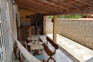 un patio avec une table et des chaises et un mur en pierre dans l'établissement Casa do campo, à Ibitipoca