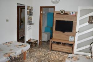 un salon avec une télévision sur une commode dans l'établissement Casa do campo, à Ibitipoca