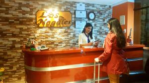 two women standing at a cash register in a restaurant at Hotel Los Nogales in Cajamarca