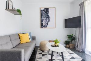 una sala de estar con un sofá y una mesa en Modern Beach Front Apartment, en Airlie Beach