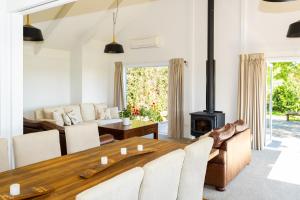 a living room with a wooden table and a fireplace at Lawn Road Retreat in Clive