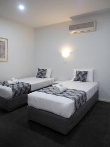 a hotel room with two beds and two lamps at Shells Apartments in Sorrento