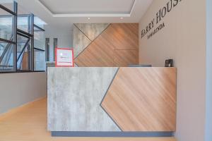 a lobby with wooden floors and a wall with a sign at RedDoorz Plus near Taman Budaya Samarinda in Samarinda