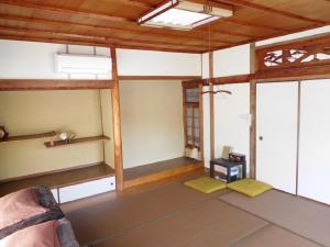 een kamer met een bed en een aantal ramen bij ゲストハウス尾道ポポー Guesthouse Onomichi Pawpaw in Onomichi