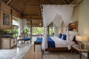 1 dormitorio con 1 cama con dosel en Puri Gangga Resort Ubud en Tegalalang