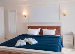 um quarto com uma cama azul e 2 toalhas em Grand Hotel Palladium em Munique