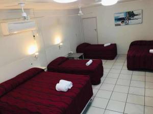 una camera d'albergo con due letti e un divano di Emerald Highlands Motel a Emerald
