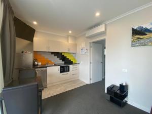 a kitchen with white cabinets and a counter top at BigSky Motels in Omarama