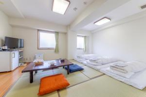 uma sala de estar com duas camas e uma mesa em Hotel Airport Komatsu em Komatsu