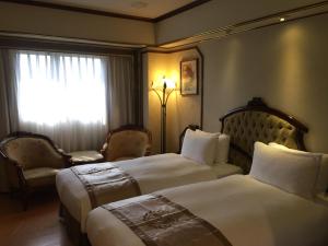 Postel nebo postele na pokoji v ubytování Charming City Songshan Hotel