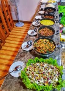 una mesa larga con muchos platos diferentes de comida en Dambulla Shan Inn en Dambulla