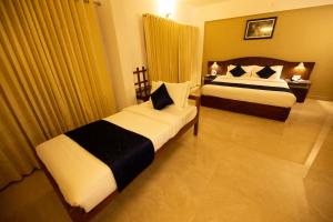 En eller flere senge i et værelse på Hotel Guruvayur Darshan