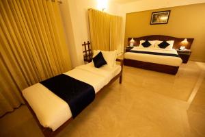 a hotel room with two beds in a room at Hotel Guruvayur Darshan in Guruvāyūr