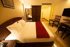 a bedroom with a large bed with a red blanket at Hotel Guruvayur Darshan in Guruvāyūr