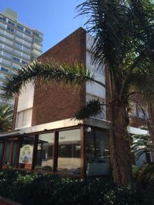 un edificio con una palmera delante de él en Hotel Gaudí, en Punta del Este