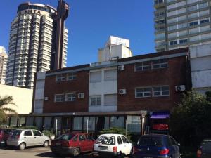 un edificio de ladrillo con coches aparcados en un aparcamiento en Hotel Gaudí, en Punta del Este