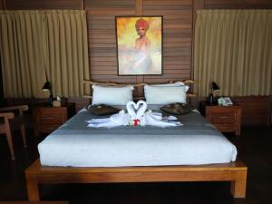 a bedroom with a bed with a bow on it at Gajah Mina Beach Resort in Selemadeg