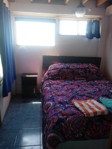 um quarto com uma cama num quarto com uma janela em Habitaciones Gabriel em Horcón