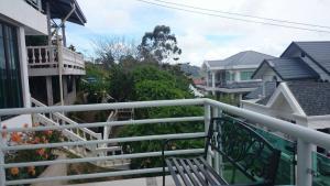 a balcony with a white railing and some houses at Seribu 1 Homestay Single Room in Kundasang