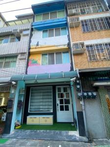 an apartment building with a front door and windows at 耶伊親子溜滑梯民宿 in Tainan