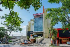 um edifício com um sinal de bar vermelho em cima em RedDoorz Plus near Hotel Benua Kendari em Pulupanda