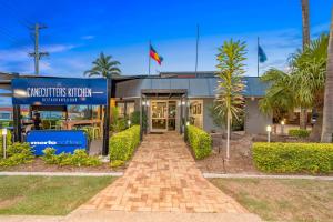 a building with a brick walkway in front of it at Sugar Country Motor Inn in Bundaberg